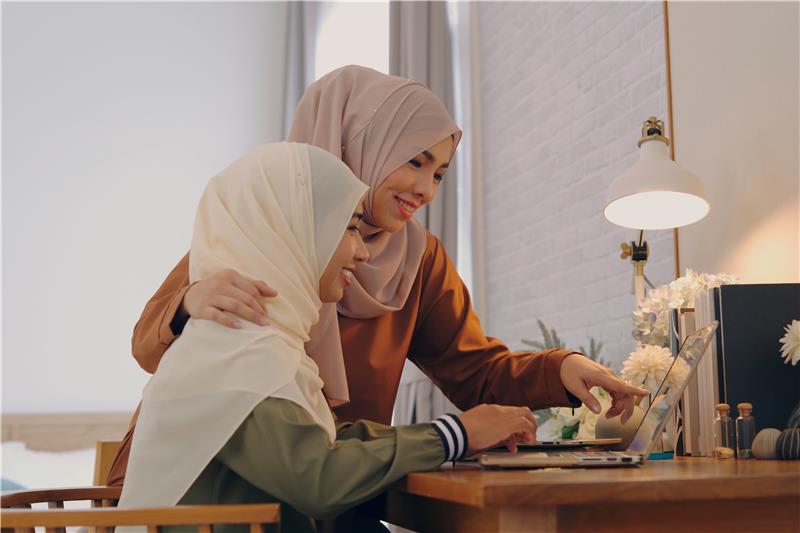 Muslim parent supporting her daughter with online learning and healthy digital habits