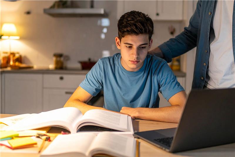Muslim teenager studying online while navigating academic focus and digital pressure.